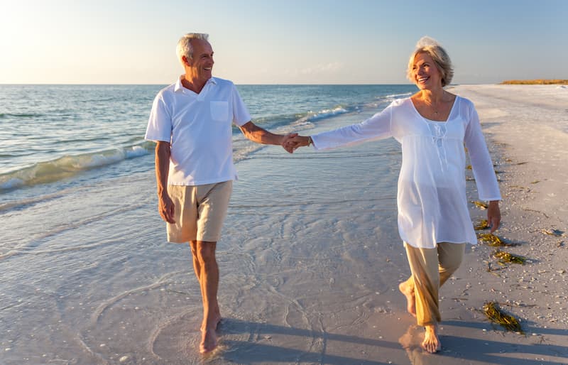 Zahnersatz Tipps zur Pflege und Haltbarkeit. Mann und Frau am Strand